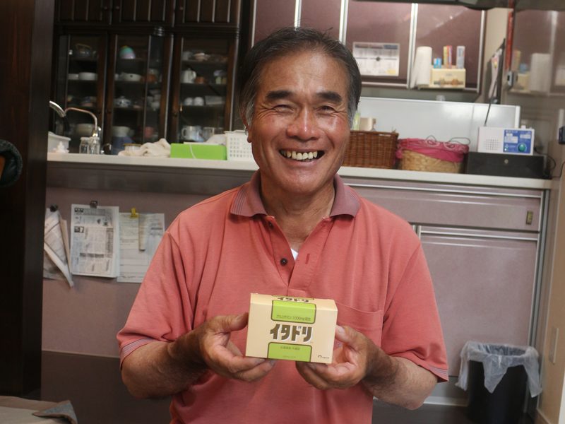 イタドリのパッケージを持つ山下重利さん